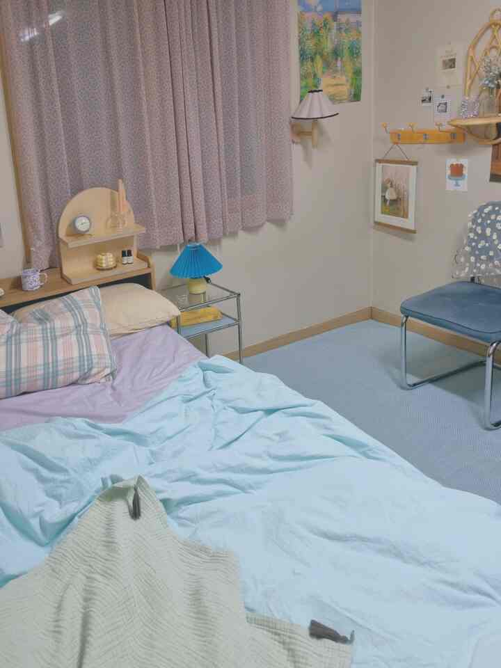 Blue and natural tone bedroom featuring posters, coat rack, and carpet creating a cozy space