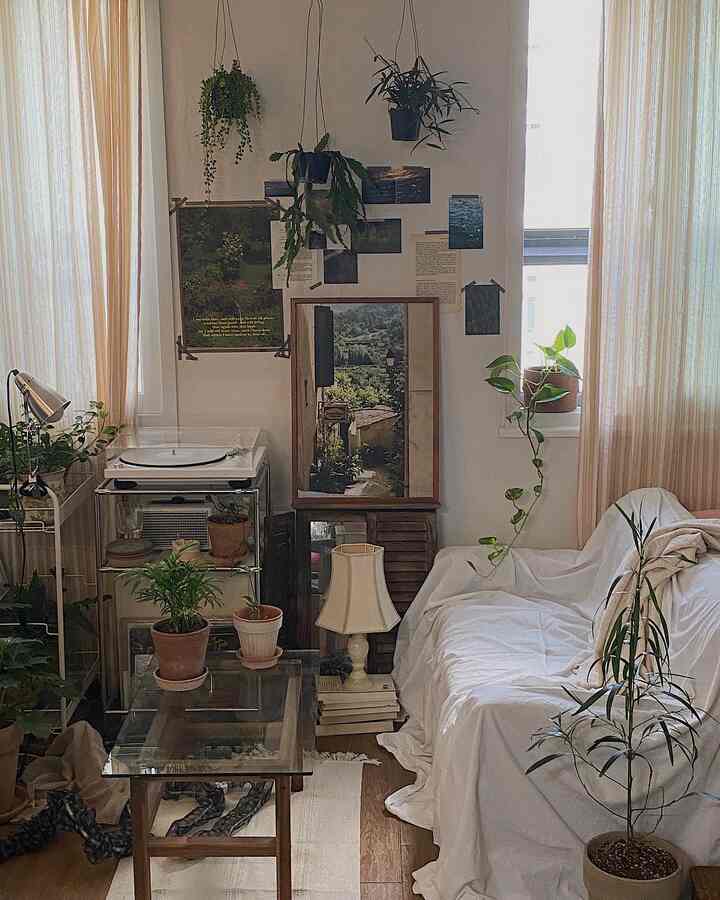 白とナチュラルカラーのリビング、植物とヴィンテージ家具が調和した落ち着いた空間