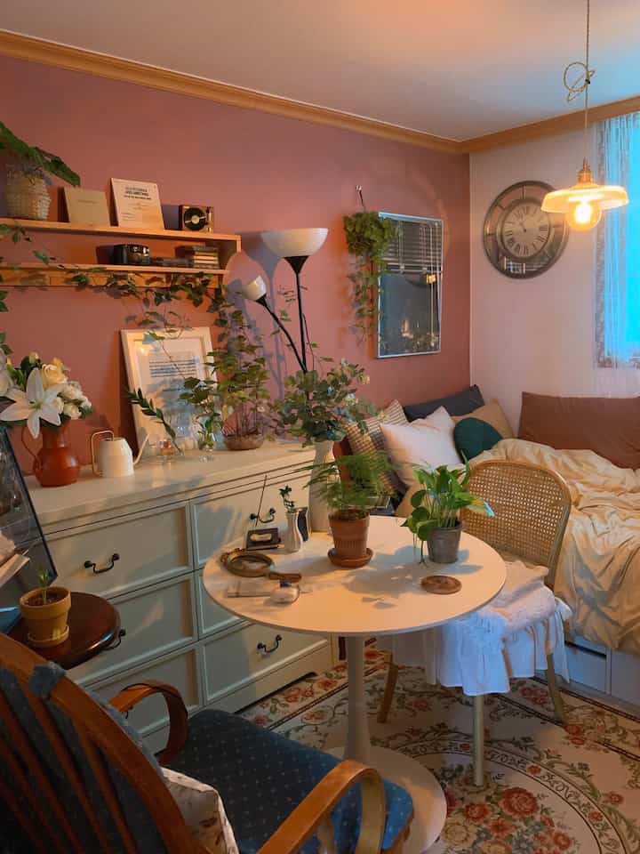 Cozy living room with warm light brown and ivory tones, featuring a round table and plants in a vintage-style interior
