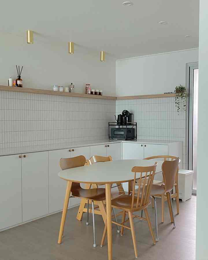 White and wood tone kitchen space featuring a simple dining table and chairs with a cozy atmosphere
