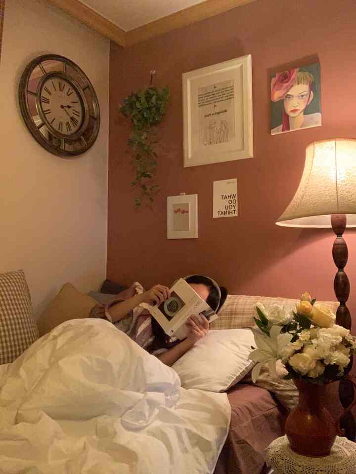 Natural brown and beige toned bedroom featuring cozy bedding, table lamp, framed art, and plants creating a warm atmosphere