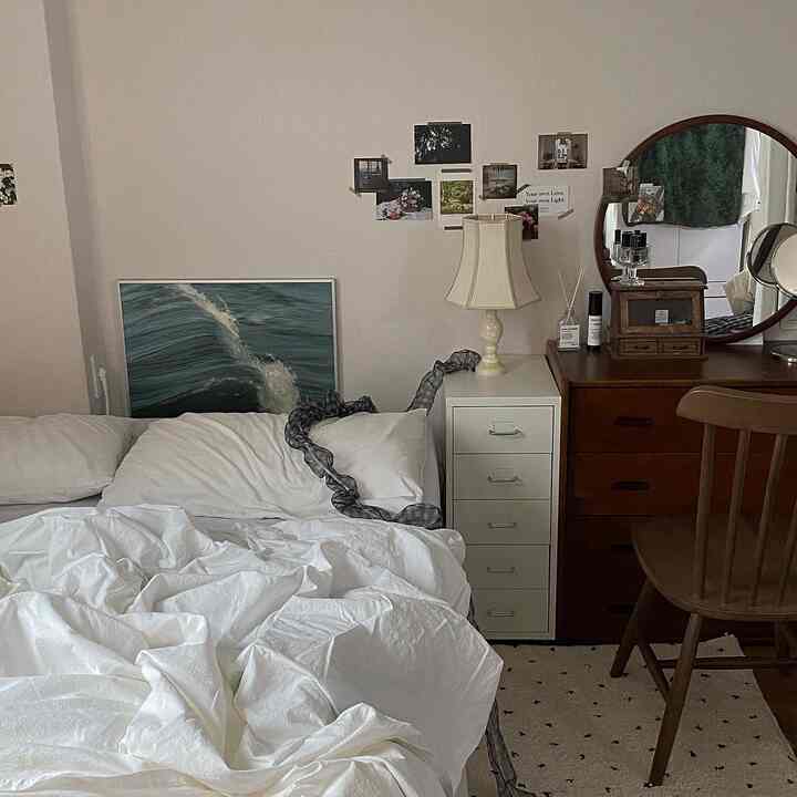 白と木目調の調和が取れたワンルームの寝室、化粧台とナイトテーブルが温かみのある雰囲気を演出する空間