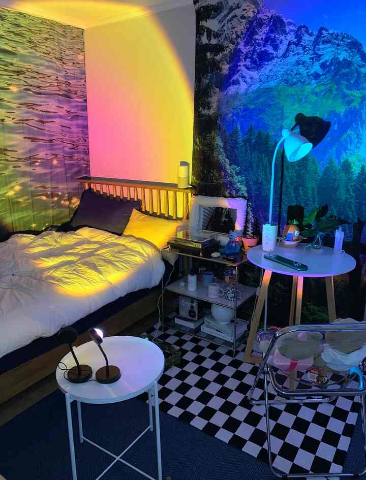 白と木目調の寝室、チェッカーボードラグと透明な椅子が配置された洗練されたミッドセンチュリーモダンの空間