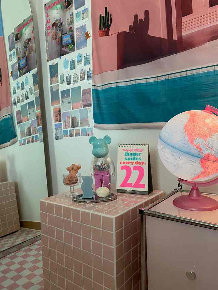 Cozy bedroom corner with pink tiled nightstand and full-length mirror, wall adorned with various posters in a modern style