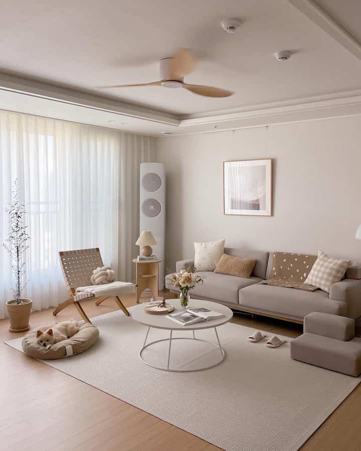Beige and wood tone living room featuring cozy sofa and pet bed creating a warm, comfortable space