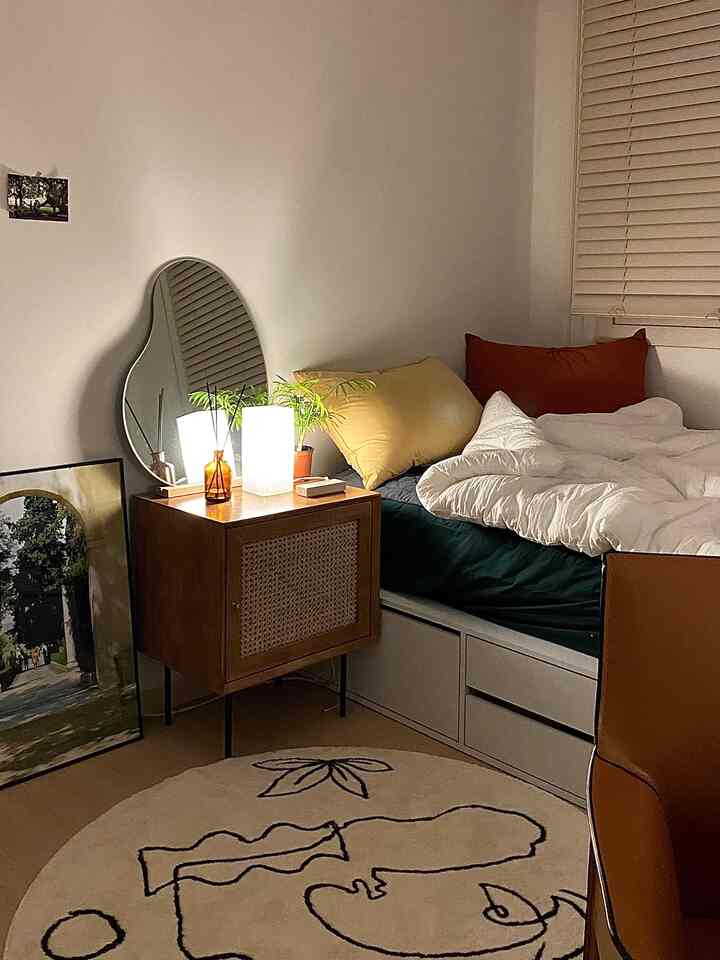 Cozy bedroom with warm wood-toned furniture and white bedding creating a natural atmosphere