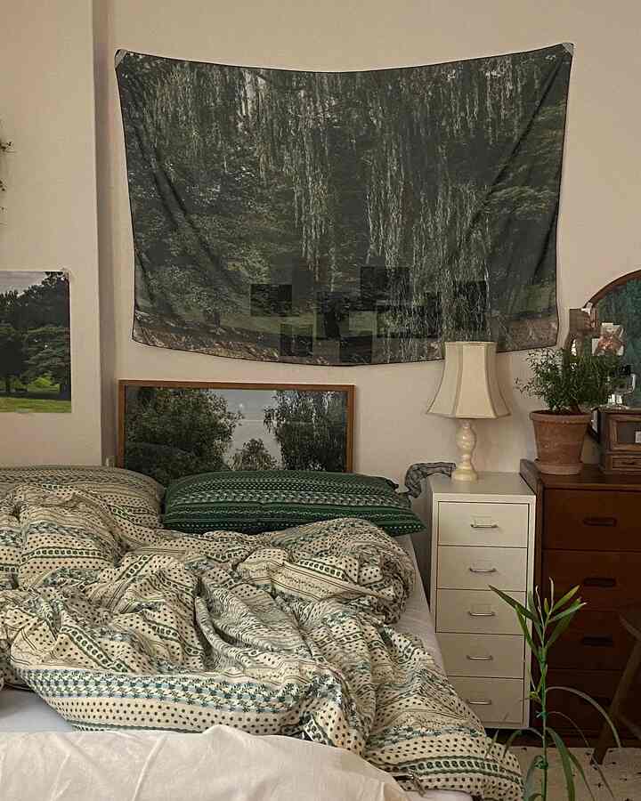 ナチュラルなグリーンとホワイトの寝室、木製のチェストと植物が配置された雰囲気のあるヴィンテージインテリア