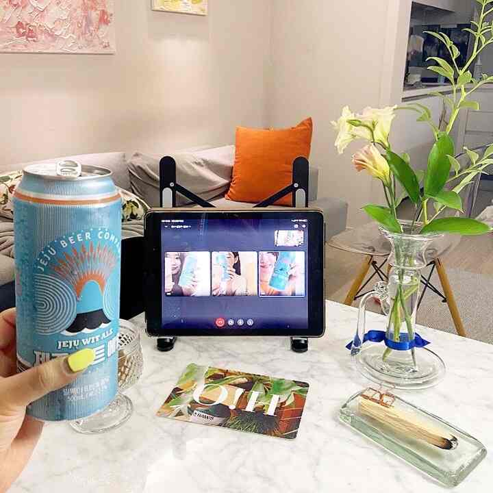Living room in gray and blue tones featuring a marble table with tablet, can, and vase creating a cozy natural atmosphere