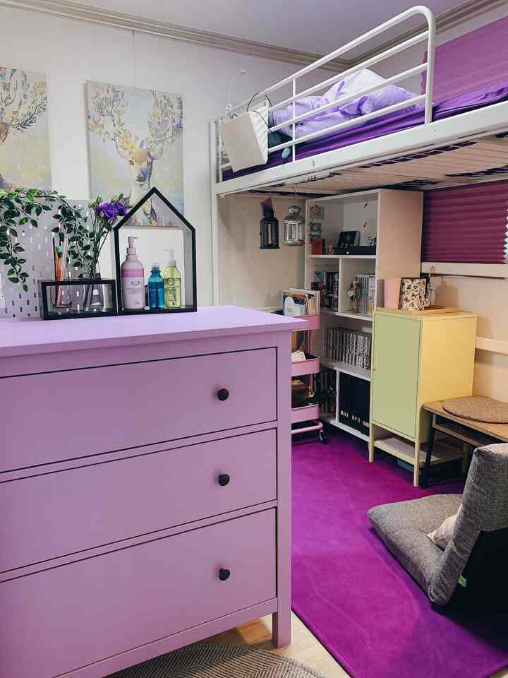 Lavender-toned compact small room featuring a bunk bed, lavender dresser, purple carpet, and a cozy resting area