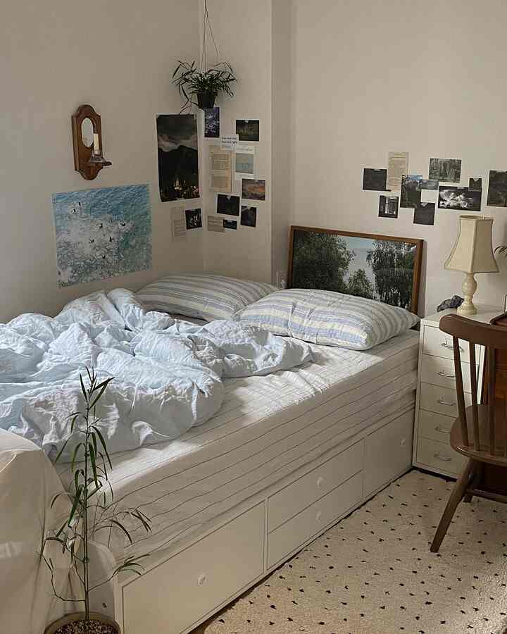 白い壁とライトブラウンの家具、植物が配されたナチュラルな寝室の雰囲気あるインテリア