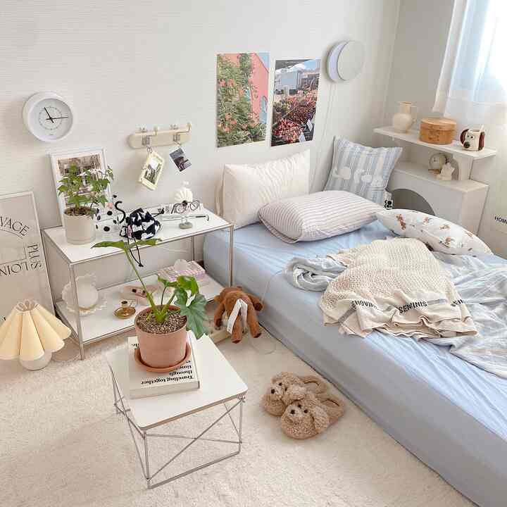 White and blue toned bedroom featuring plants and dog-themed accessories with a cozy and natural atmosphere