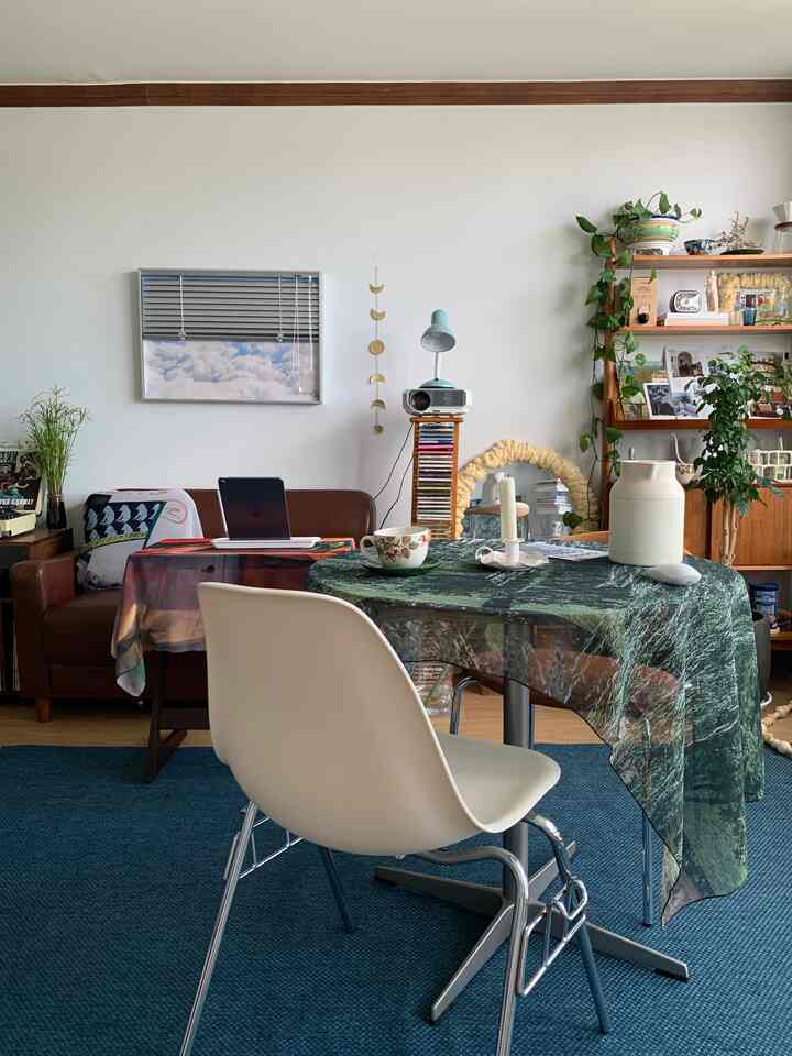Beige and brown wood-toned living room featuring a round table and white chair, creating a natural and cozy atmosphere