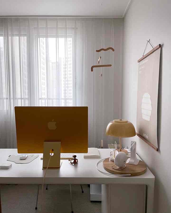 Bright white and beige toned home office featuring a modern desk and table lamp with a clean, minimal atmosphere