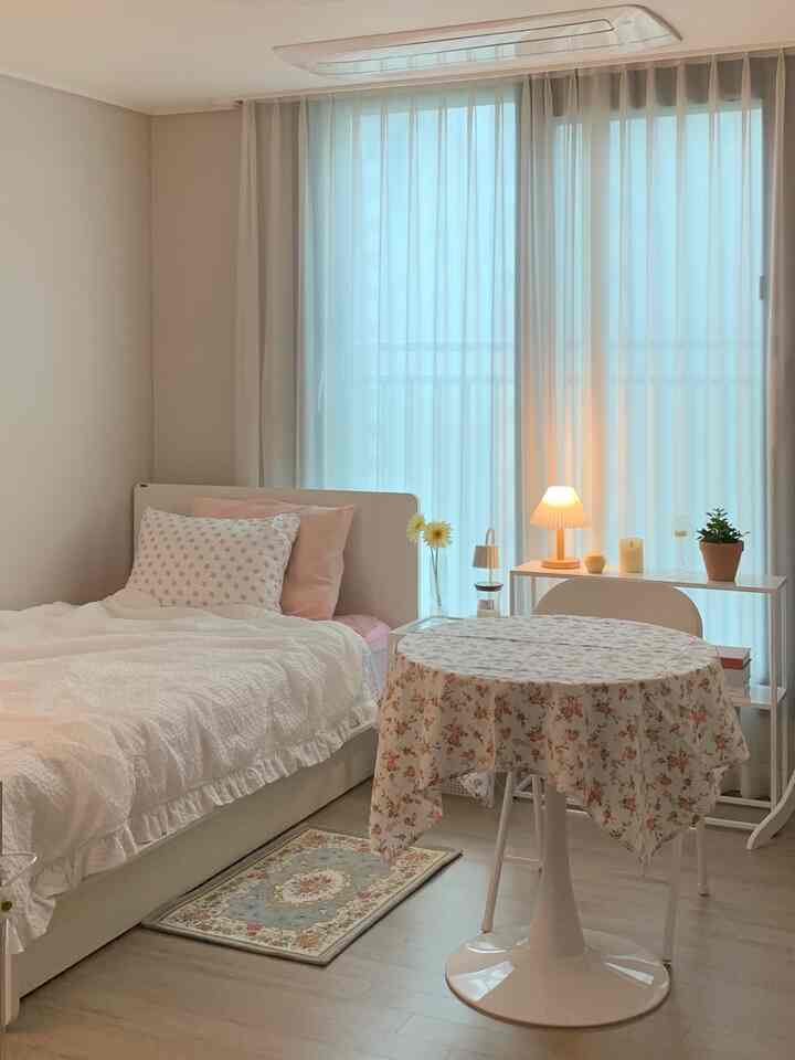 Natural and white-toned bedroom featuring a single bed and a floral tablecloth creating a cozy atmosphere