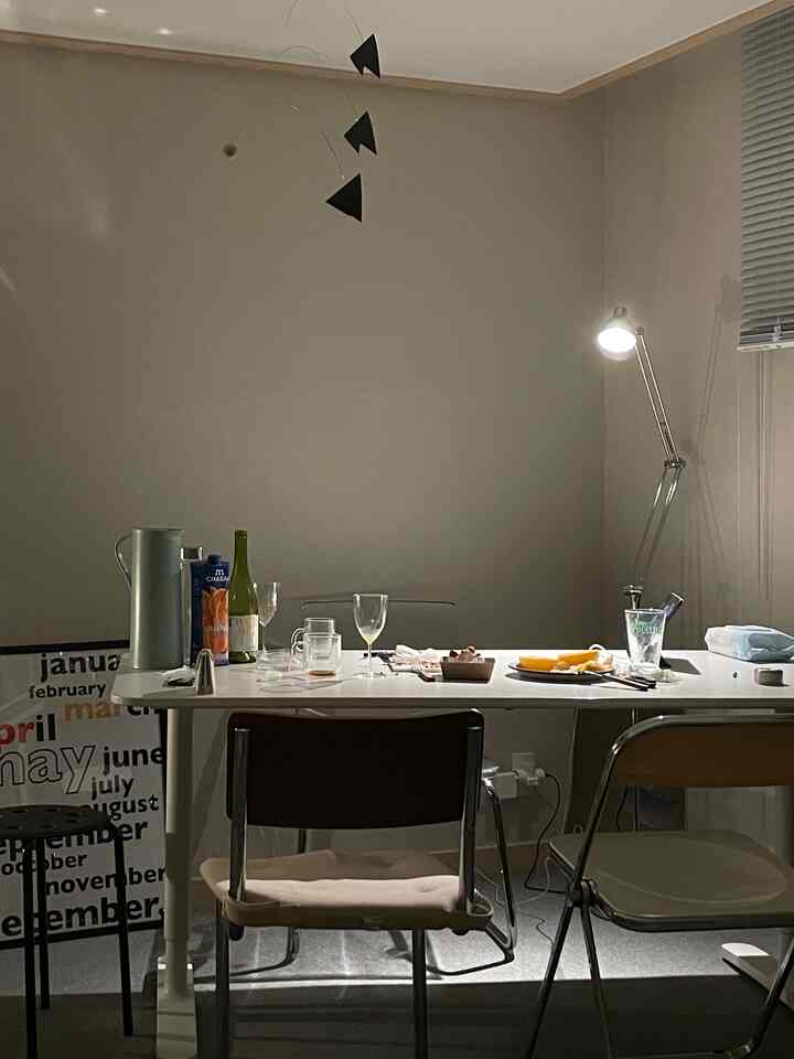 Black and white toned kitchen dining space with a cluttered table, low lighting creating a cozy night atmosphere