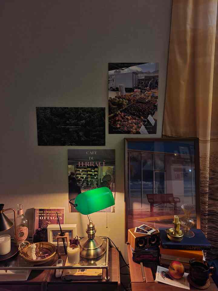Warm wood tones and gold accents highlight a vintage retro living room table setup with picture frames and a green desk lamp