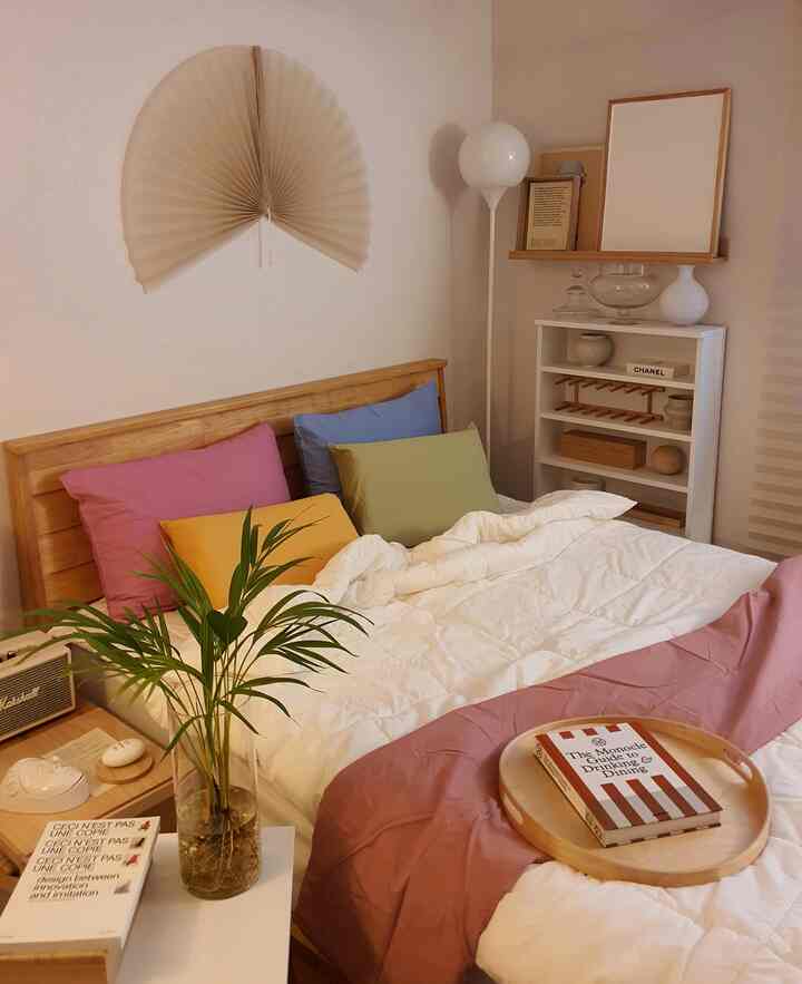 Natural tone bedroom featuring white bedding with colorful pillows creating a cozy atmosphere