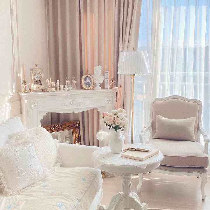 A white and beige toned living room featuring elegant sofa and armchair in French Country style atmosphere