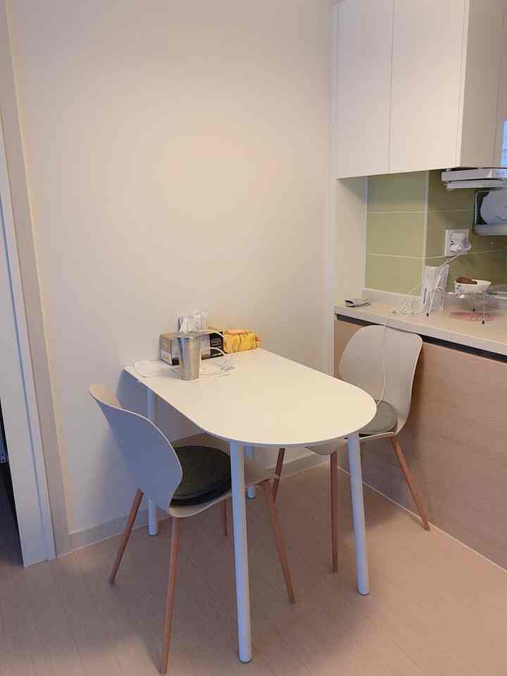 白と木目調が調和したコンパクトなキッチンスペース、シンプルでモダンなダイニングテーブルと椅子が配置された居心地の良いダイニングルーム