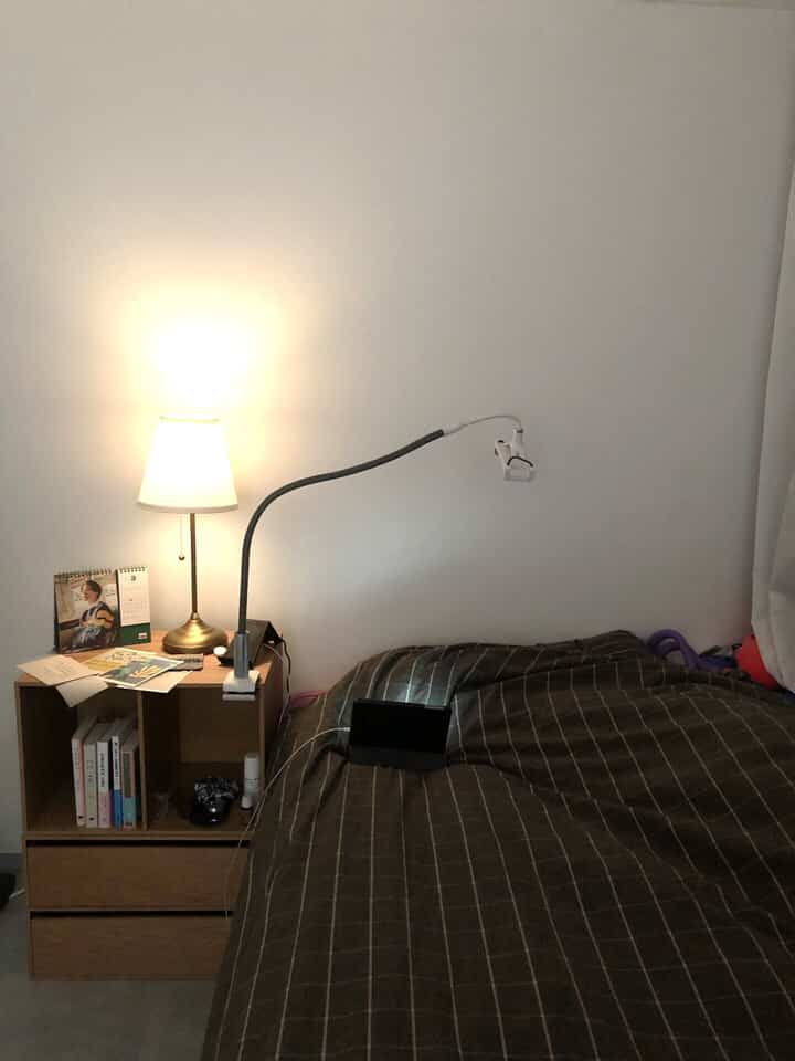 Bedroom with white walls and wood-toned nightstand, featuring brown checkered bedding creating a cozy atmosphere