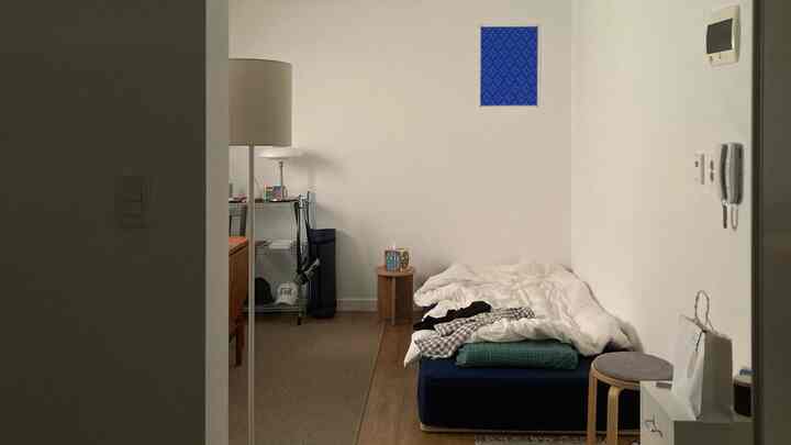 白と木目調が調和した一人用寝室、シンプルな家具配置が際立つナチュラルモダンな空間