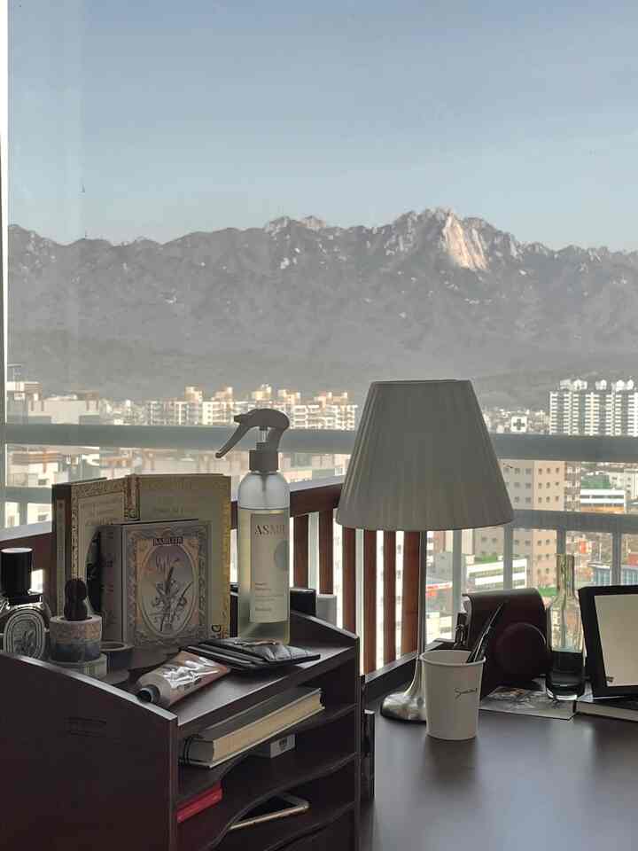 Wood tone and white study space with balcony view, featuring desk and lamp in a neat atmosphere