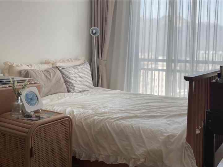 A cozy bedroom with soft beige and natural tones, featuring a rattan storage cabinet and white bedding creating a harmonious atmosphere