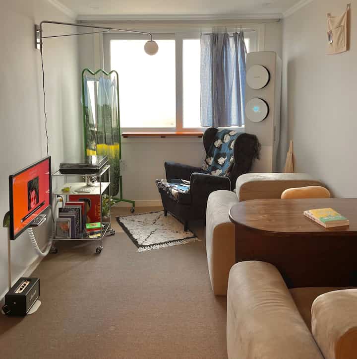 Beige and blue toned compact living room featuring sofa, armchair, and wood coffee table with a simple and natural atmosphere