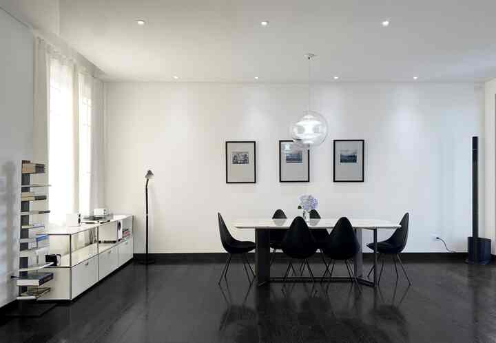 Simple modern living room with white walls and black dining furniture creating a harmonious space