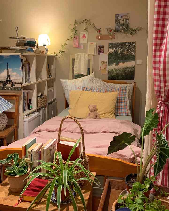 温かみのあるベージュ色調の寝室、木製ベッドと花柄の枕、多様な植物が配置された居心地の良い空間