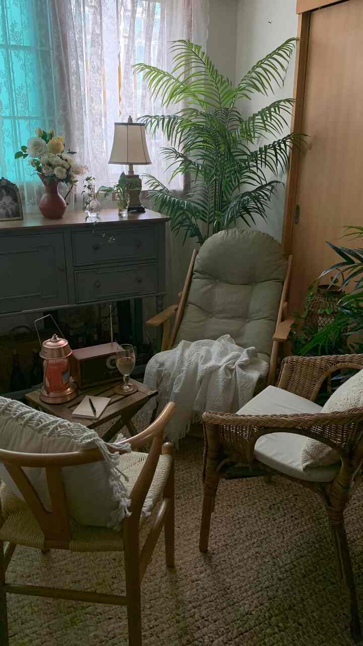 ナチュラルな色調のリビング、木製家具と緑の植物が配置された雰囲気のあるヴィンテージスタイルのインテリア