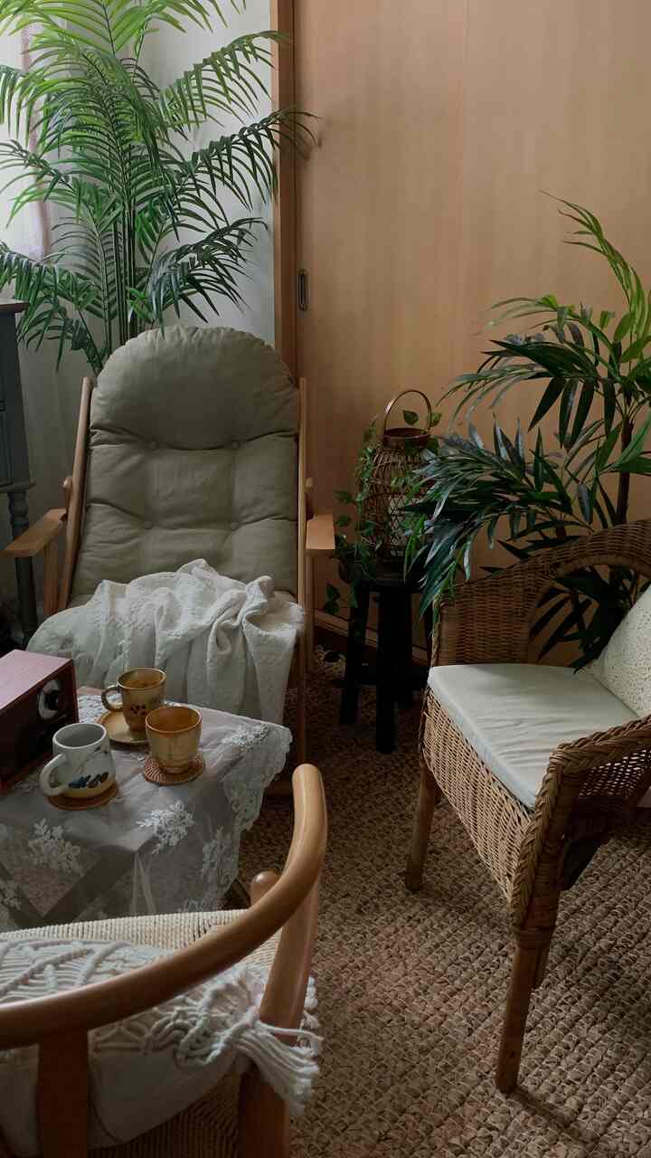 A natural-toned vintage living room featuring rattan furniture and a cozy home cafe vibe