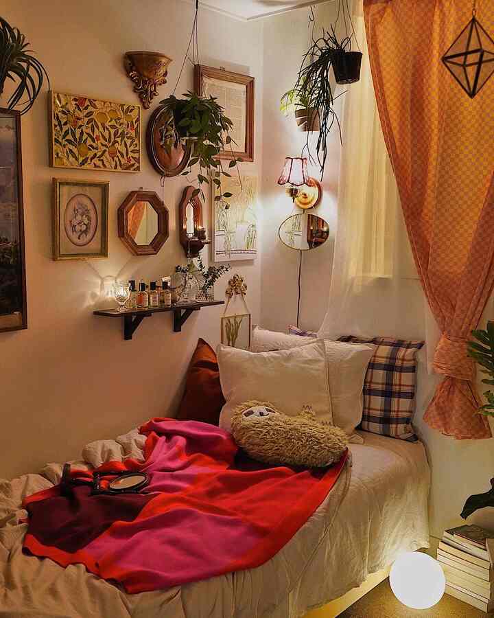 Cozy bedroom with warm orange curtains and vintage decor, featuring beige bedding and white pillows centered on the bed