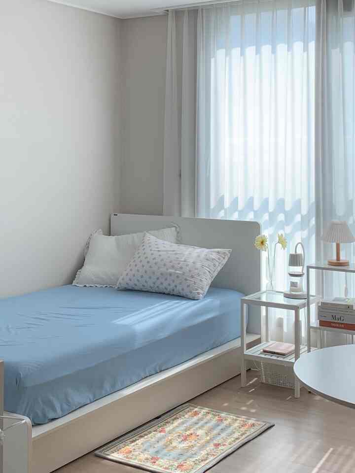 A natural modern bedroom in white and wood tones featuring a bed and side tables with a cozy and neat atmosphere