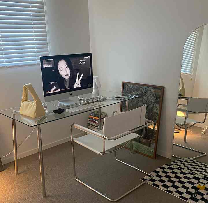 ホワイトと透明なガラスが調和するミッドセンチュリーモダンのホームオフィス、シンプルで洗練された印象の机と椅子が配置された空間