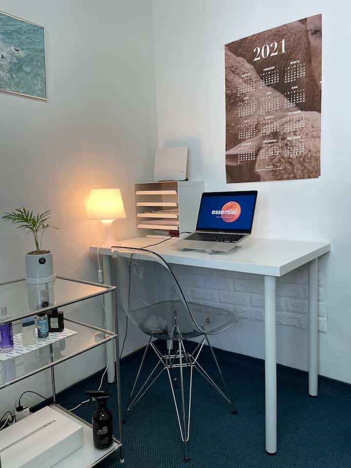 White and transparent themed single-person home office featuring modern desk, lamp, and compact layout