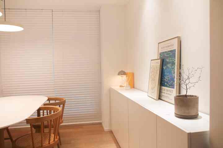 White and wood tone dining room featuring a white dining table and wooden dining chairs, showcasing a clean and natural atmosphere
