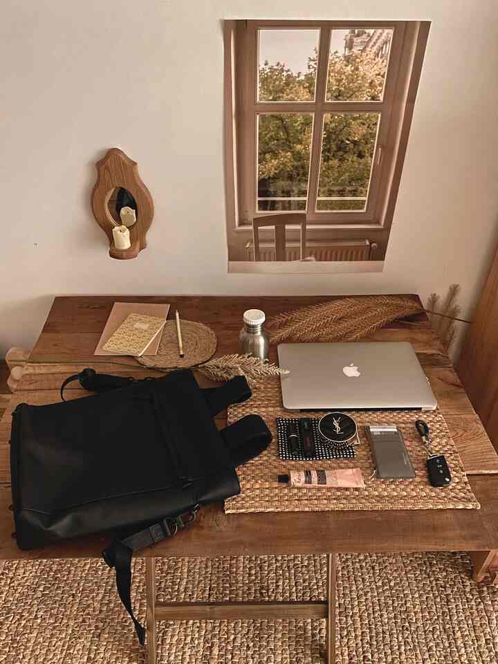 Natural tone home office space featuring a wooden desk with neatly arranged laptop and accessories for focused work