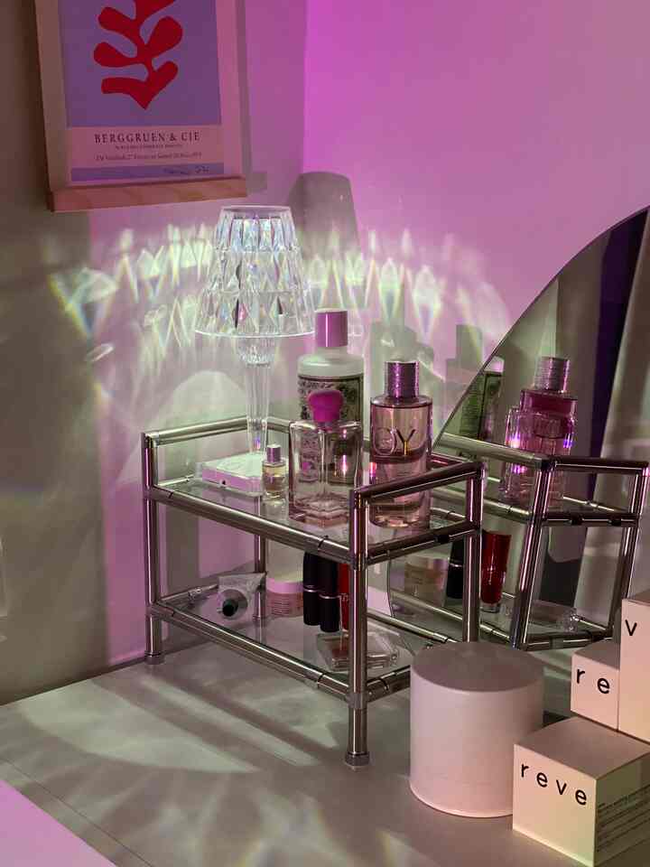 Modern vanity area with pink mood lighting and chrome modular shelf creating a clean atmosphere