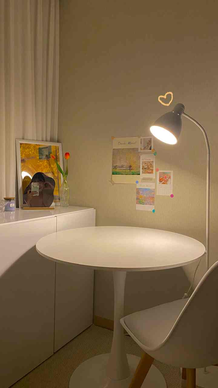 Beige walls and white round dining table illuminated by clean lighting in a simple, cozy single household space