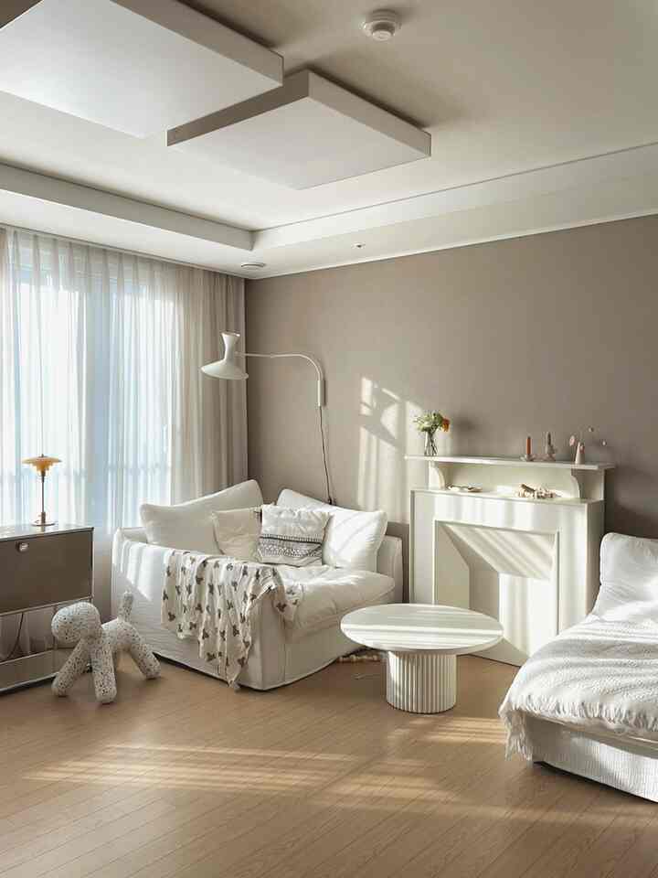 A beige and white toned living room featuring two sofas and a round coffee table, creating a cozy natural atmosphere