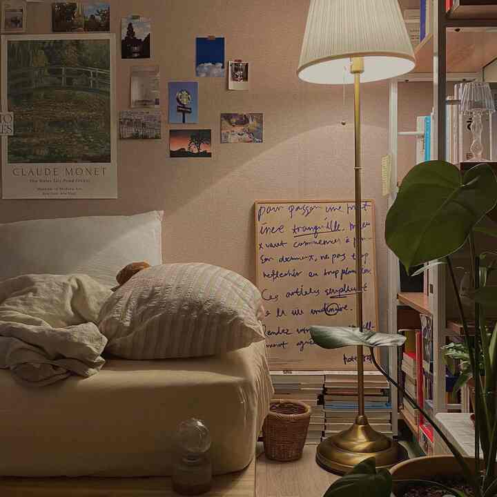 ベージュとウッドトーンで温かみのある寝室、ベッドと本棚、フロアランプが落ち着いた読書空間を演出