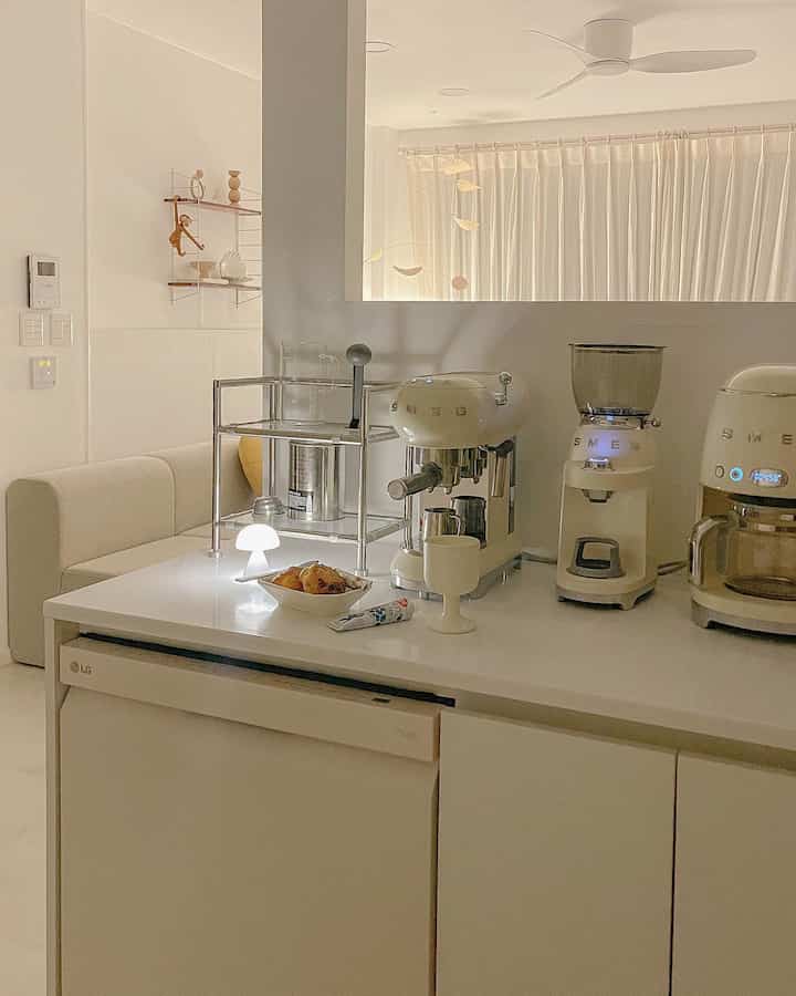 White and ivory toned kitchen home cafe featuring SMEG coffee machines and LG Objet Collection dishwasher in a clean, modern setting