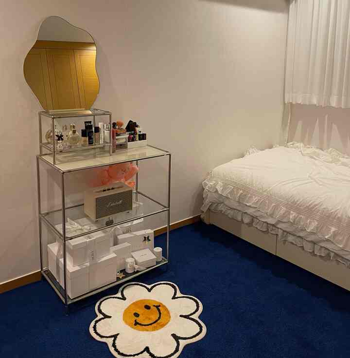 Modern bedroom featuring navy rug, transparent modular furniture, white bedding, and sheer curtains