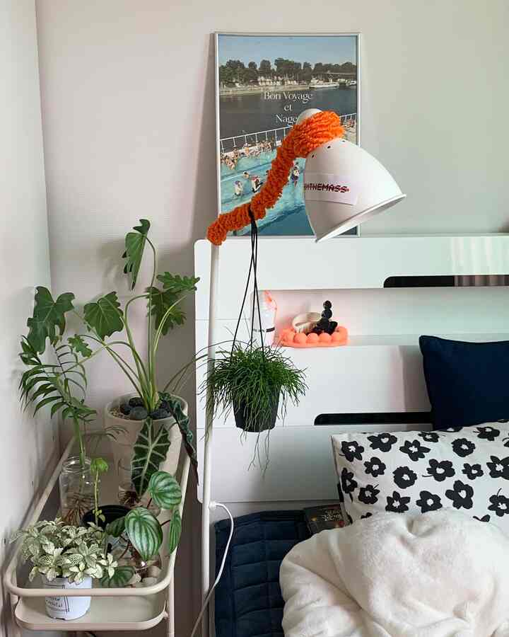 白とネイビーの色調の寝室、様々な緑の植物が配置されたシンプルでナチュラルな雰囲気のインテリア