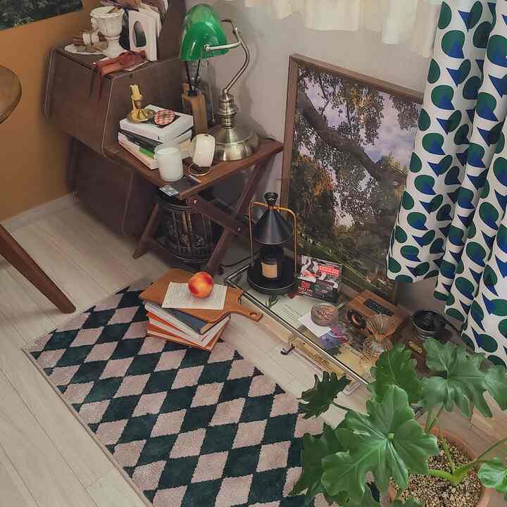 A cozy space with natural wood tones and green accents, featuring a modular desk rack, vintage decor, and patterned curtains creating a warm retro atmosphere