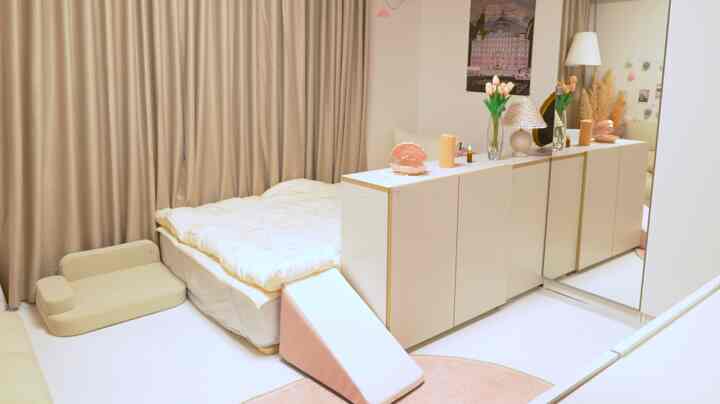 Ivory and beige toned bedroom featuring a bed, pet steps, and pet bed in a cozy and minimal setting