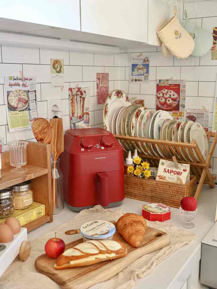 Vintage-style kitchen featuring a red air fryer and wooden utensils with warm, cozy atmosphere