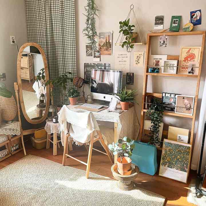 暖かい木目調とナチュラルな色調のリビングルームホームオフィス、デスクと植物、ヴィンテージカーテンが調和した居心地の良い空間