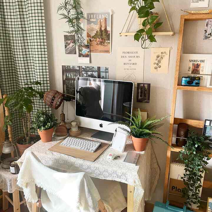 Beige and white toned home office with a desk featuring a computer and plants creating a cozy atmosphere
